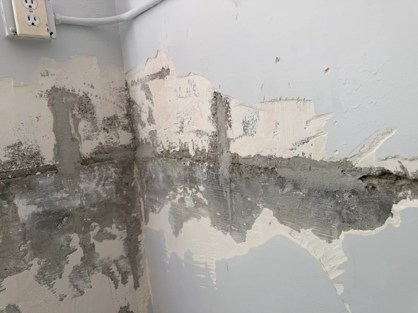 Interior wall with damaged plaster and exposed substrate