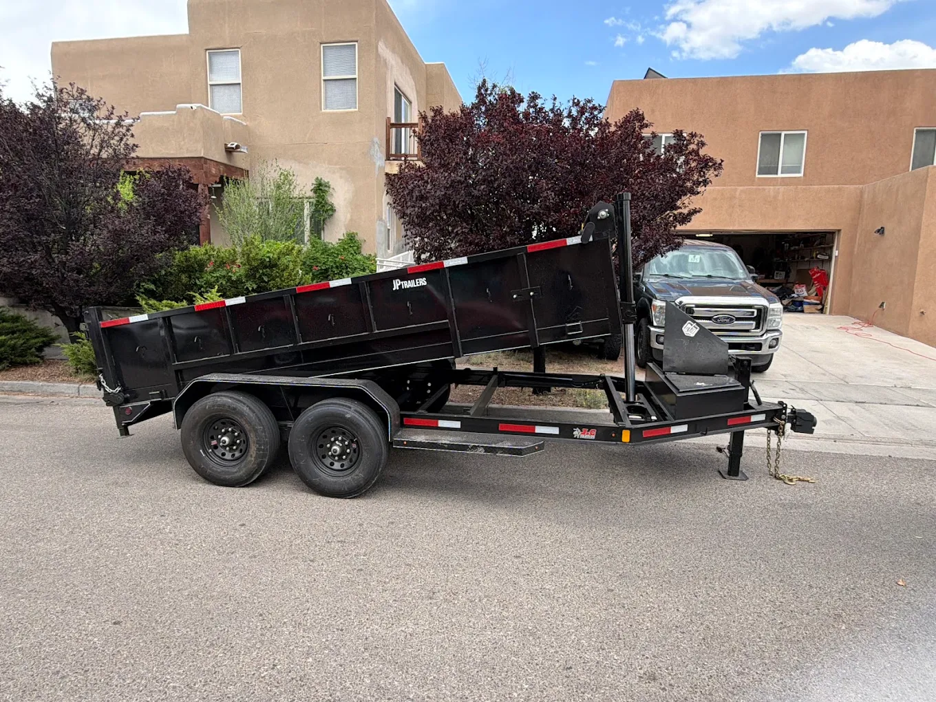 Dump trailer parked in front of an adobe-style home